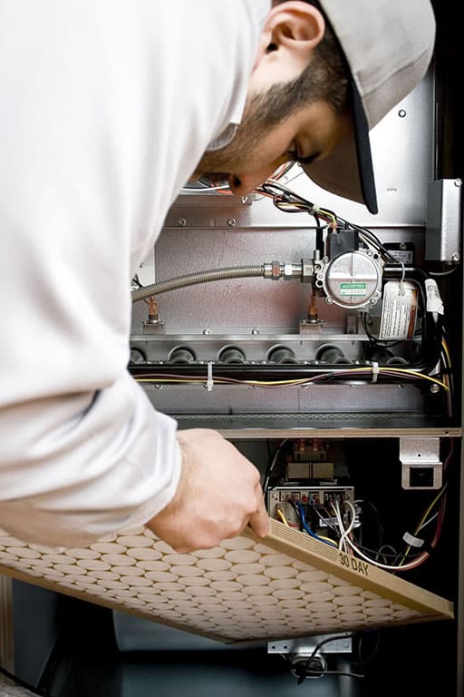 Technician performing heating service at a home in Colorado Springs