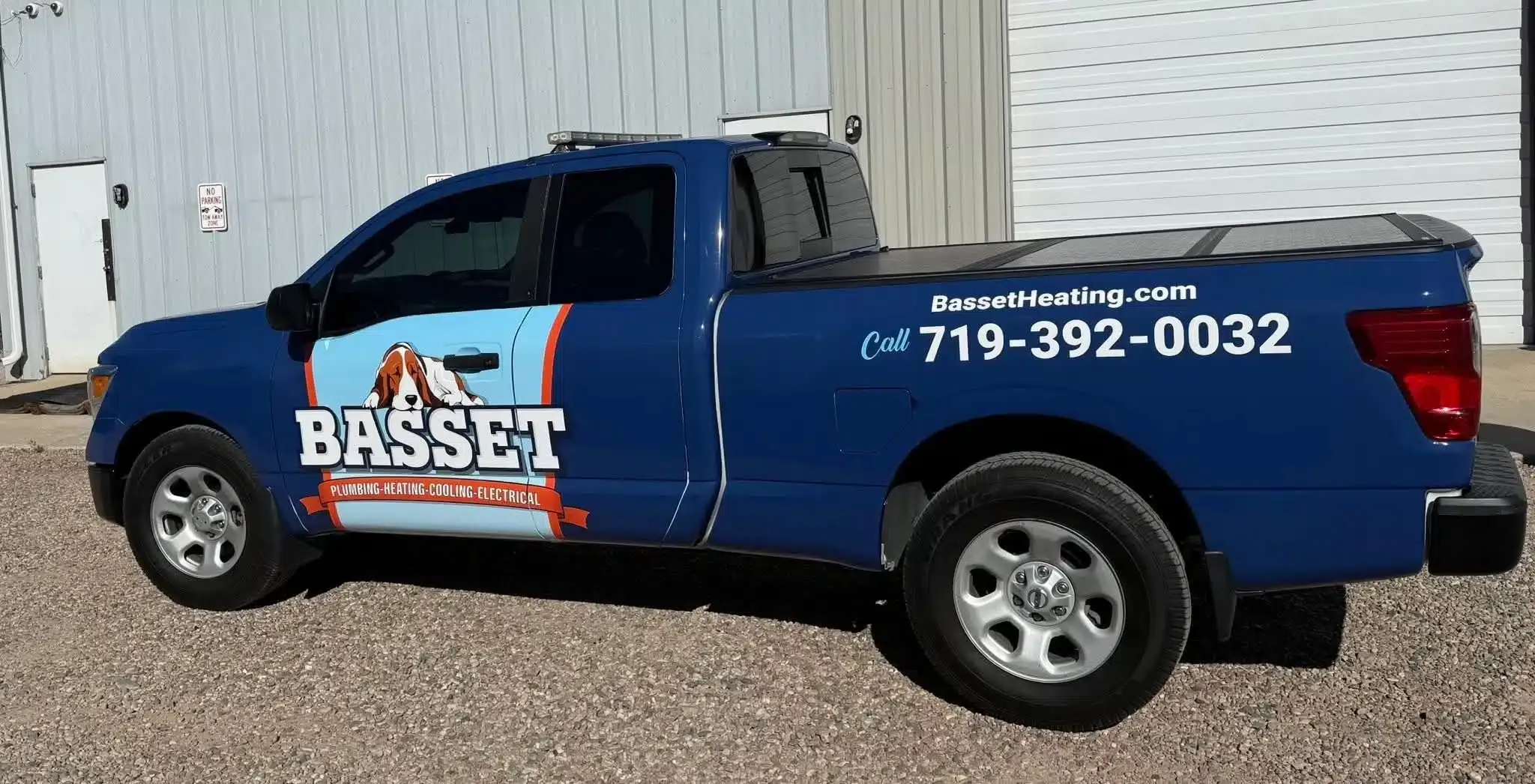 Blue BASSETT service truck displaying phone number and website for plumbing and cooling services in Colorado