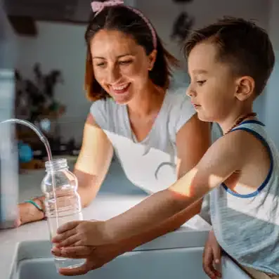 mother and son filling water in kitchen sink in Colorado Springs, CO.